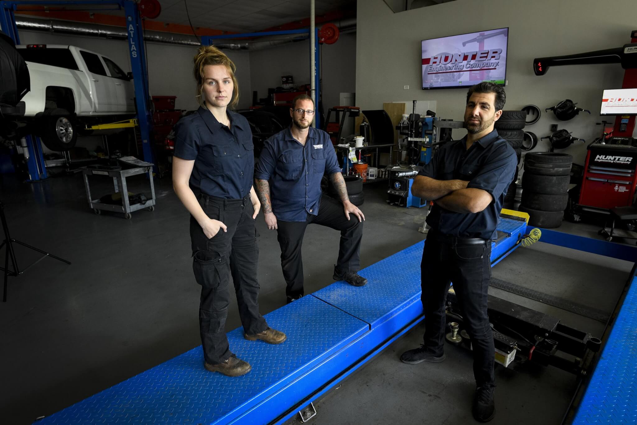 THree techs standing in an automotive shop