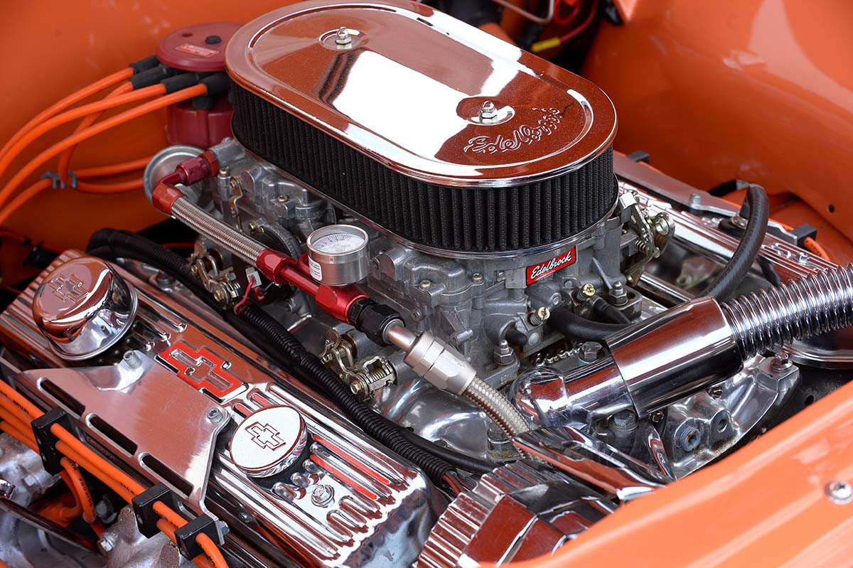 An engine sits in the bay of a muscle car.