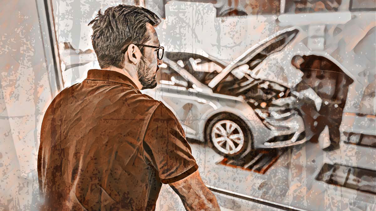 A man watches as his car is worked on,