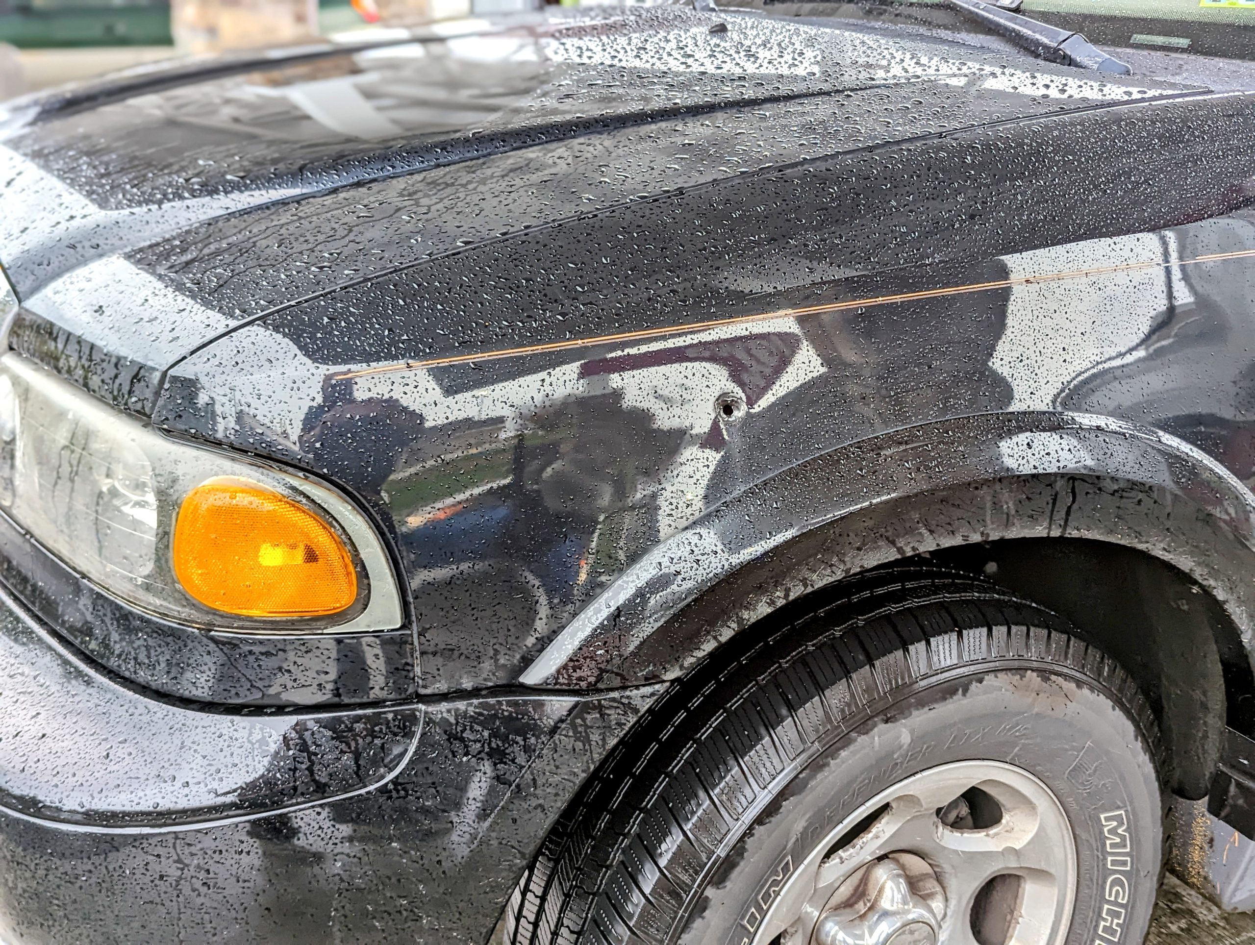 Car with bullet hole in fender.