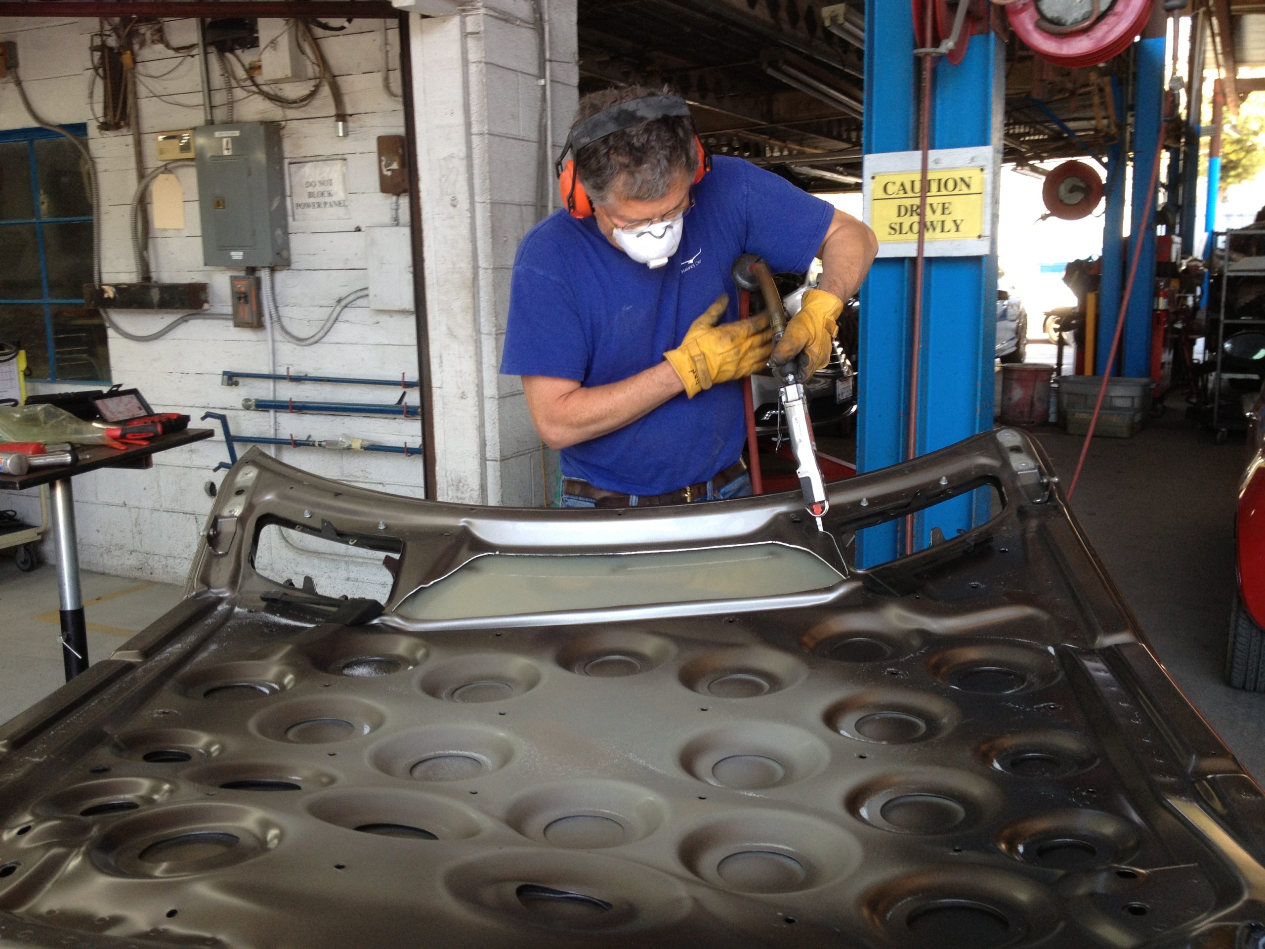 Photo of Dan Schimpke cutting up a vehicle panel to make jewelry for CRASH.