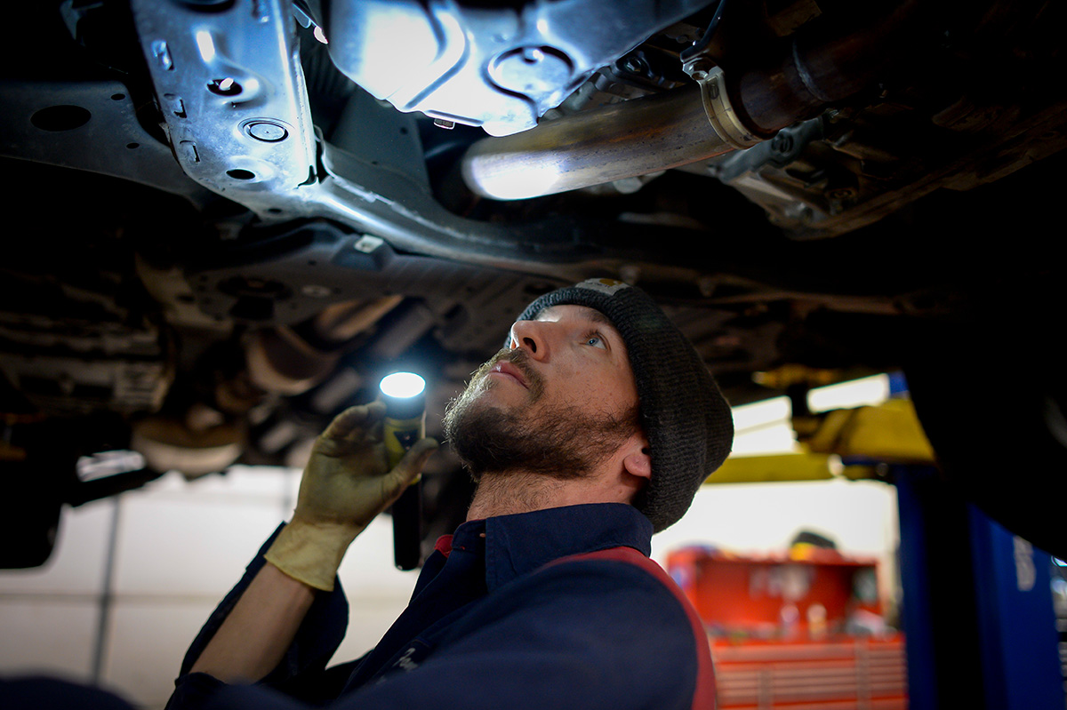 technician inspecting vehicle undercarriage