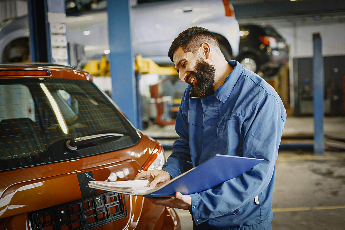 Mechanic Holding Papers On Phone